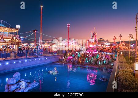 26 février 2021, Émirats Arabes Unis, Dubaï : fontaine illuminée et canal d'eau avec un globe de bronze sur la place dans Global Village Banque D'Images