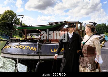 Henrichenburg, Waltrop, Allemagne. 8 août 2021. La vapeur est à votre service ! Un couple à l'aspect victorien pose par le Franz-Christian, un cargo patrimonial restauré. Les fans et les visiteurs de steampunk, dont beaucoup ont des tenues rétro-futuristes complètes, se réunissent pour la journée sencond du festival du marché du Jubilé de Steampunk au site historique de Henrichenburg, sur le canal Dortmund-EMS, aujourd'hui un site du patrimoine industriel. Les vieilles structures et les bateaux forment une toile de fond pour le festival en plein air. Credit: Imagetraceur/Alamy Live News Banque D'Images