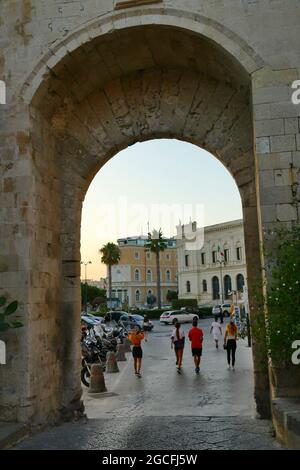 SYRACUSE, ITALIE - 14 juillet 2021 : photo d'une vue sur la place avec une belle architecture à travers une ancienne arche de l'île d'Ortigia. Banque D'Images