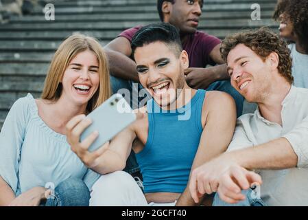 Jeunes amis faisant selfie avec téléphone mobile en plein air dans la ville - Focus sur le visage d'homme gay Banque D'Images