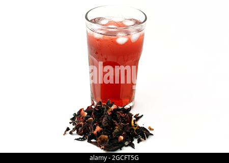 Verre de jus de Roselle frais et réfrigéré avec des herbes de Roselle séchées isolées sur fond blanc, un jus de wonjo de biscap avec des glaçons Banque D'Images