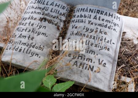 'Al-Fatiha' le chapitre d'ouverture du Livre Saint musulman, Coran écrit sur marbre à la tête d'une tombe musulmane en plein air Banque D'Images