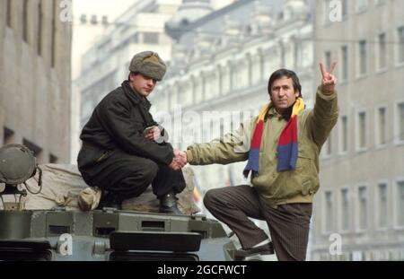 Bucarest, Roumanie, janvier 1990. L'acteur George Mihaita discutant avec les soldats dans les rues dans les jours troumpants juste après la chute du communisme. Banque D'Images