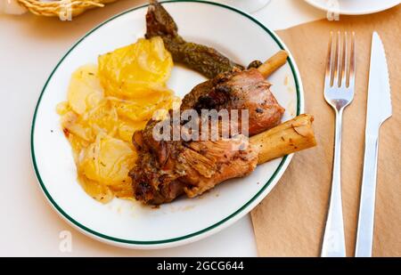 Les oignons calcottes sont servis sur une assiette avec une sauce Romesco - plat traditionnel catalan Banque D'Images