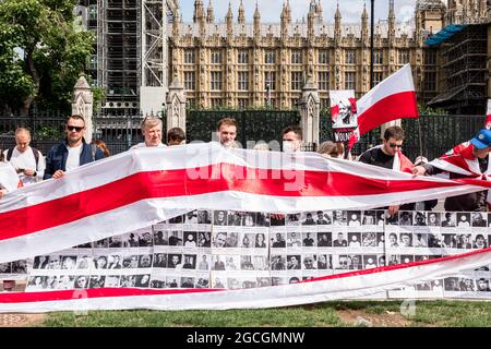 Londres, Royaume-Uni. 08 août 2021. Les manifestants tiennent des pancartes avec des photos de prisonniers politiques pendant la manifestation. Les Biélorusses se sont rassemblés sur la place du Parlement et ont ensuite défilé vers le pont de Westminster, accrochant un drapeau de la Biélorussie au-dessus du pont. Le 8 août marque un an depuis les élections présidentielles falsifiées de 2020. La marche a protesté contre les personnes sans droit sous le régime Loukachenko et appelle à la liberté des prisonniers politiques. Crédit : SOPA Images Limited/Alamy Live News Banque D'Images