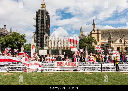 Londres, Royaume-Uni. 08 août 2021. Les manifestants tiennent des pancartes avec des photos de prisonniers politiques pendant la manifestation. Les Biélorusses se sont rassemblés sur la place du Parlement et ont ensuite défilé vers le pont de Westminster, accrochant un drapeau de la Biélorussie au-dessus du pont. Le 8 août marque un an depuis les élections présidentielles falsifiées de 2020. La marche a protesté contre les personnes sans droit sous le régime Loukachenko et appelle à la liberté des prisonniers politiques. Crédit : SOPA Images Limited/Alamy Live News Banque D'Images