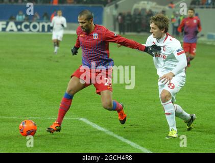 BUCAREST, ROUMANIE - 16 FÉVRIER 2012 : Geraldo Alves (L) de la FCSB et Luuk de Jong (R) de Twente photographiés en action pendant la première partie de l'UEFA Europa League Round de 32 entre la FCSB et le FC Twente à l'arène nationale en 2011/12. Banque D'Images