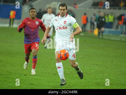 BUCAREST, ROUMANIE - 16 FÉVRIER 2012 : Peter Wisgerhof (R) de Twente photographié en action pendant la première partie de l'UEFA Europa League Round of 32 2011/12 entre la FCSB et le FC Twente à l'arène nationale. Banque D'Images