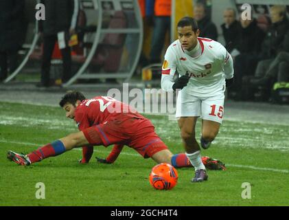 BUCAREST, ROUMANIE - 16 FÉVRIER 2012 : Roberto Rosales (R) de Twente passe par Raul Rusescu (L) de la FCSB lors de la première partie de l'UEFA Europa League Round de 32 entre la FCSB et le FC Twente à l'arène nationale en 2011/12. Banque D'Images