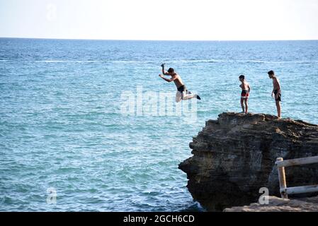 Roda de Bara, Espagne. 05 août 2021. Un jeune homme plonge dans la mer depuis une falaise à la plage du Roc de Sant Gaieta à Roda de Bara.les jeunes sautent des falaises à la plage du Roc de Sant Gaieta à Roda de Bara (Tarragone Espagne), une pratique qui est interdite, dangereux et peut causer de graves blessures corporelles et même la mort par l'impact contre les roches. Crédit : SOPA Images Limited/Alamy Live News Banque D'Images