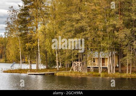 Petite île sur le lac avec une maison de campagne en Finlande. Banque D'Images