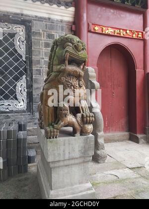 Une statue de gardien de lion en pierre et un cub sur un poteau au temple de hui Guang dans l'ancien quartier de Lizhuang de la ville de Yibin Banque D'Images