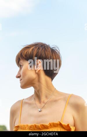Portrait en bas-angle joyeuse femme d'âge moyen debout au bord de la rivière dans le remblai de la ville Banque D'Images