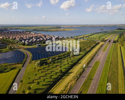 Quartier résidentiel moderne et innovant d'Almere, le long du bord de l'eau, avec champ de panneaux solaires. Pays-Bas, Flevoland. Banque D'Images