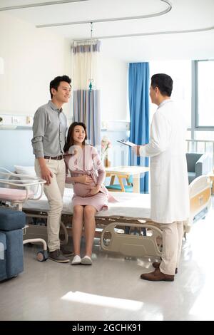 Femme enceinte parlant avec un médecin dans la salle d'hôpital Banque D'Images
