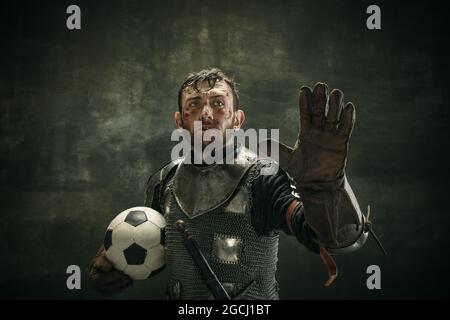 Portrait d'un homme barbu brutal, d'un guerrier médéival ou d'un chevalier avec une balle sur fond sombre. Banque D'Images