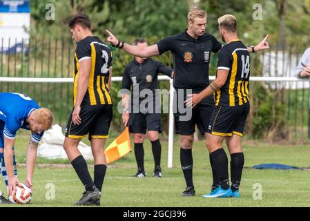 Arbitre indiquant 'plus' à un joueur pendant Southend Manor versus London Colney FC dans le Round Extra préliminaire de la coupe FA. Gesticulation Banque D'Images