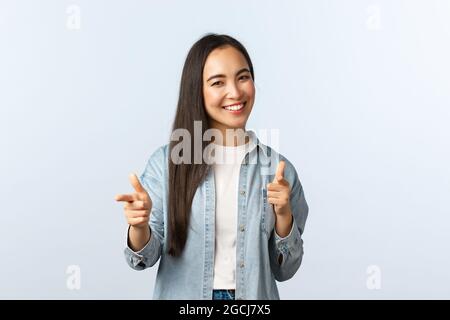 Style de vie, émotions et beauté des gens. Une femme asiatique amicale et gcheeky félicite un ami, en louant un bon travail ou en disant bien plaquée comme pointant Banque D'Images