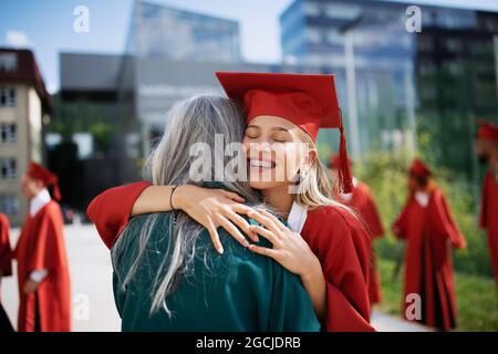 Portrait d'un étudiant universitaire joyeux qui célèbre l'extérieur, concept de remise des diplômes. Banque D'Images