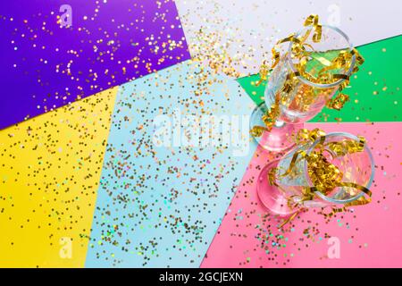 Deux verres de champagne avec des sparkles et des confettis de Noël avec place pour le texte sur un fond coloré Banque D'Images