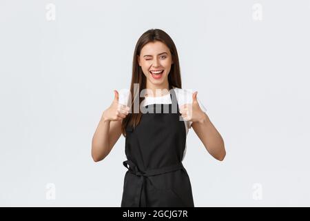 Concept des employés d'épicerie, des petites entreprises et des cafés. Une femme de barista enthousiaste et joyeuse se montre très enthousiaste. Vendeur noir Banque D'Images