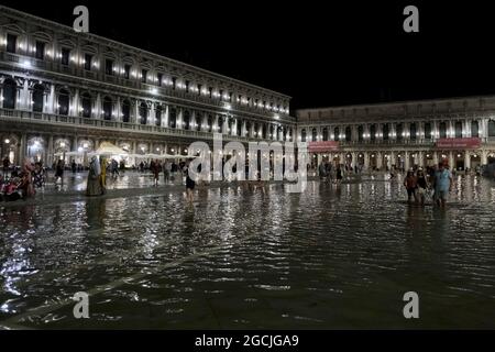 Les gens marchent sur une place Saint-Marc inondée pendant une haute eau exceptionnelle à Venise, Italie le 8 août 2021.(MVS) Banque D'Images