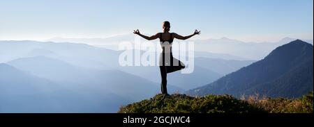 Vue arrière d'une femme sportive debout sur une jambe tout en pratiquant le yoga à l'extérieur le matin. Vue panoramique Banque D'Images