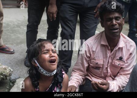 Non exclusif: DHAKA, BANGLADESH - AOÛT 7: Un enfant désarpe, alors que voir comme sont livrés les restes dans les cercueils, des parents qui sont morts dans la dea Banque D'Images