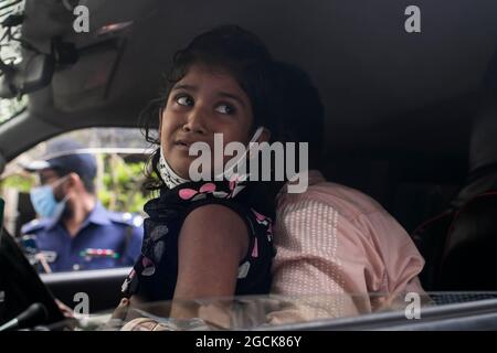 Non exclusif: DHAKA, BANGLADESH - AOÛT 7: Un enfant désarpe, alors que voir comme sont livrés les restes dans les cercueils, des parents qui sont morts dans la dea Banque D'Images