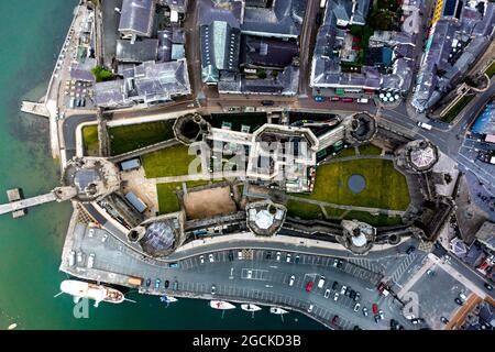 Vue aérienne par drone du château de Caernarfon et des remparts le long de la rivière Seiont dans le nord du pays de Galles Banque D'Images