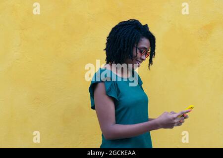 Portrait d'une jeune femme envoyant un message sur smartphone dans la rue. Banque D'Images