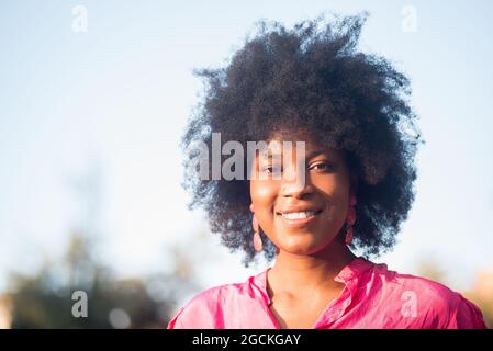 Femme médecin spécialiste en uniforme de protection, gants en latex et masque facial effectuant un test de bouche avec un coton-tige sur la femme afro-américaine i Banque D'Images