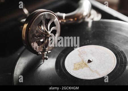 Phonographe vintage avec disque vinyle noir joue une vieille musique, gros plan photo avec une mise au point douce sélective Banque D'Images