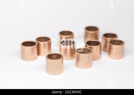 Les roulements en bronze à dix manchons se tiennent sur un fond blanc, photo de gros plan avec mise au point douce sélective Banque D'Images