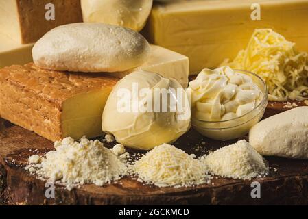 Collection de fromages italiens entiers et râpés sur table en bois Banque D'Images
