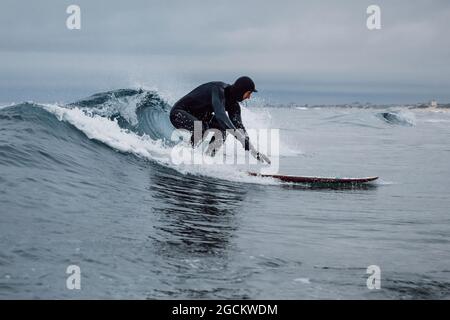 30 avril 2021. Anapa, Russie. Surfer en combinaison sur planche de surf à la vague du baril. Banque D'Images