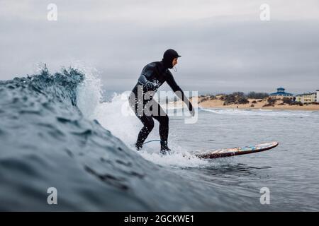 30 avril 2021. Anapa, Russie. Surfer en combinaison sur planche de surf à la vague du baril. Banque D'Images