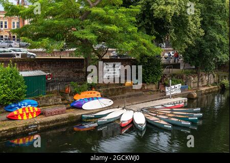 Vue depuis le pont sur Prince of Wales Road en regardant la rivière Wensum avec des canoës et des kayaks à louer sur la rive de la rivière. Banque D'Images