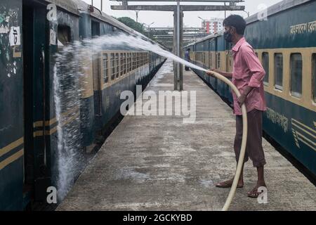 Dhaka, Bangladesh. 09e août 2021. Un employé de chemin de fer nettoie un train à la gare de Kamalapur. Les services de transport public sur terre, sur rail et sur les voies navigables doivent reprendre leurs activités après la fin du confinement de Covid-19. La Division du Cabinet a publié dimanche une circulaire confirmant que le verrouillage strict à l'échelle nationale ne sera pas prolongé au-delà de la date limite actuelle, le 10 août. Crédit : SOPA Images Limited/Alamy Live News Banque D'Images