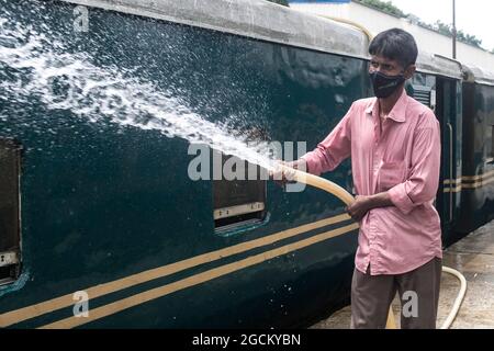 Dhaka, Bangladesh. 09e août 2021. Un employé de chemin de fer nettoie un train à la gare de Kamalapur. Les services de transport public sur terre, sur rail et sur les voies navigables doivent reprendre leurs activités après la fin du confinement de Covid-19. La Division du Cabinet a publié dimanche une circulaire confirmant que le verrouillage strict à l'échelle nationale ne sera pas prolongé au-delà de la date limite actuelle, le 10 août. Crédit : SOPA Images Limited/Alamy Live News Banque D'Images