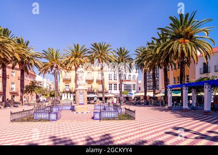 Statue de Marie dédiée à la conception imaculate Plaza de la Laguna surmontée de palmiers et de restaurants. Ayemonte Espagne Banque D'Images