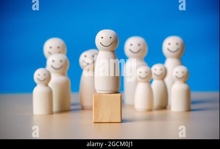 Figure en bois se tenant sur le bloc de bois à la discussion de leadership pour l'influence, l'autonomisation et l'inspiration pour la foule. Ligne d'attache avec influence, ligne d'attache Banque D'Images