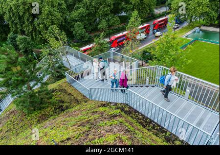 Londres, Royaume-Uni. 9 août 2021. La vue de haut en ouest où le chantier a été remplacé par du gazon frais - le Marble Arch Mound de 2 millions de livres sterling, a été annoncé en février et vient d'être rouvert gratuitement en août après un « faux départ ». Les visiteurs peuvent monter jusqu'au pic de 25 mètres où une terrasse panoramique offre une vue à 360 degrés sur Oxford Street et Hyde Park, offrant une vue jamais vue par le grand public. Sur leur chemin, les visiteurs descendent dans un espace creux qui sera utilisé pour les expositions. Il sera ouvert aux visiteurs jusqu'en janvier 2022.' Conçu par la société hollandaise Banque D'Images