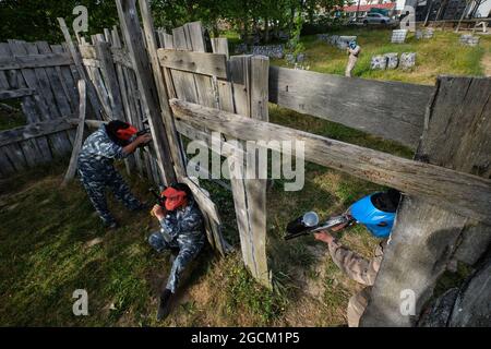 Par dessus les équipes avec des joueurs en vêtements de camouflage jouant paintball et visant à d'autres pendant le match Banque D'Images