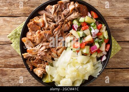 Porc Kalua cuit lentement hawaïen servi avec du chou et de la salade en gros plan sur une assiette sur la table. Vue horizontale du dessus Banque D'Images