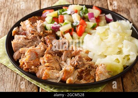 Kalua porc cuisine hawaïenne lentement cuite et servie avec du chou ragoût et de la salade fraîche dans une assiette sur la table. Horizontale Banque D'Images