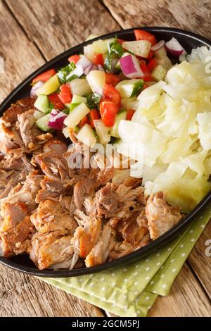 Kalua Pork le célèbre porc de style luau fait facile dans le lent cuit servi avec le chou ragoût et la salade fraîche de la ferme sur la plaque d'ardoise sur la table. Banque D'Images