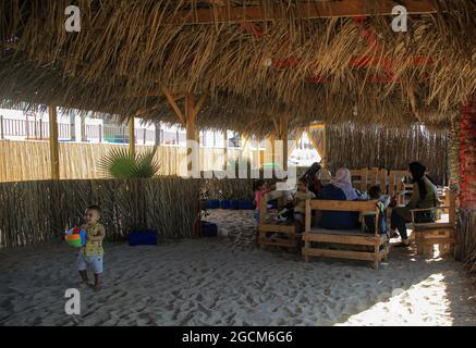 Gaza. 28 juillet 2021. Les Palestiniens apprécient leur séjour dans un café écologique sur la plage de Gaza, le 28 juillet 2021. POUR ALLER AVEC "Feature: Les Palestiniens construisent un café écologique pour la sensibilisation au recyclage des déchets" Credit: Rizek Abdeljawad/Xinhua/Alamy Live News Banque D'Images