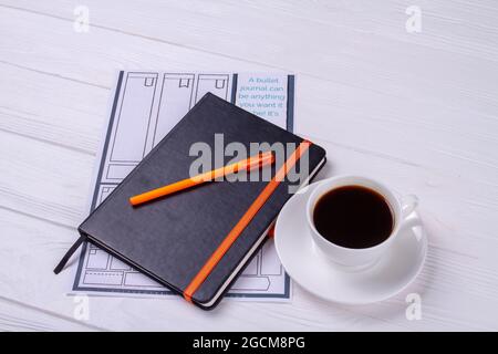 Livre avec stylo et tasse de café. Banque D'Images