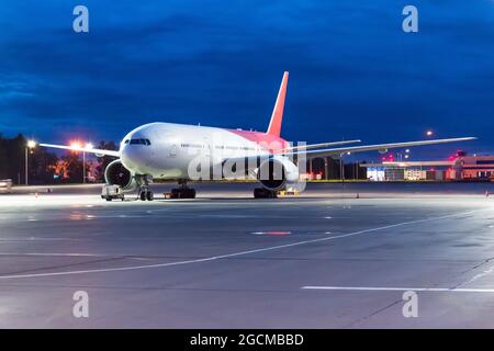 Vue de nuit sur l'aéroport et grand avion passager dans le parking avant le vol Banque D'Images